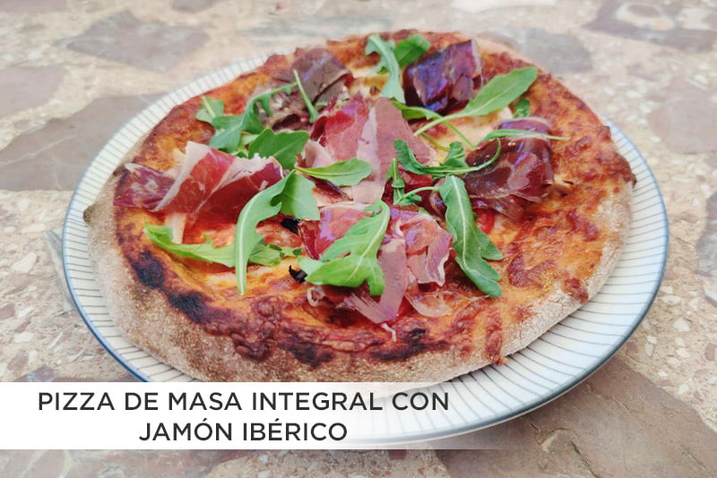 Pizza integral de jamón ibérico y rúcula